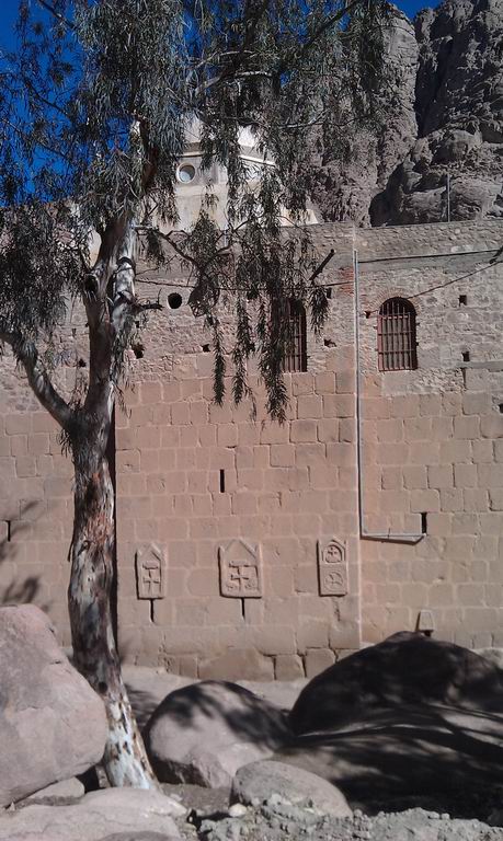 стена монастыря с разнообразными крестами